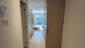 Ein Flur mit einem Holzschrank, einem Sessel und Blick auf einen Balkon.