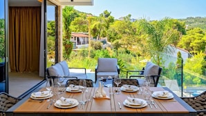 Una mesa de comedor para seis personas con vista a un paisaje exuberante.