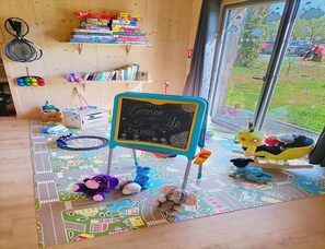 A children's play area with a chalkboard sign, toys, and books. - Villa Cottage 2 Pieces Superieur - 2 Pers (Malansac)