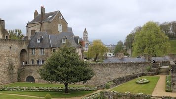 A historic stone building with a large tree in the courtyard.