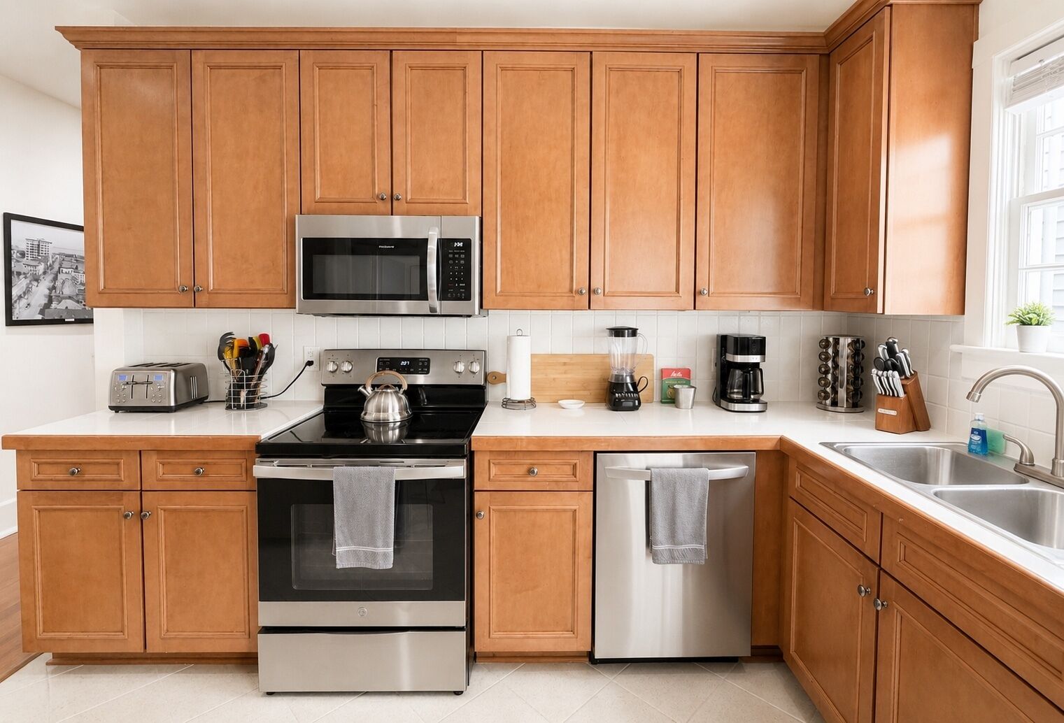 A modern kitchen with wooden cabinets, stainless steel appliances, a toaster, and a coffee maker.