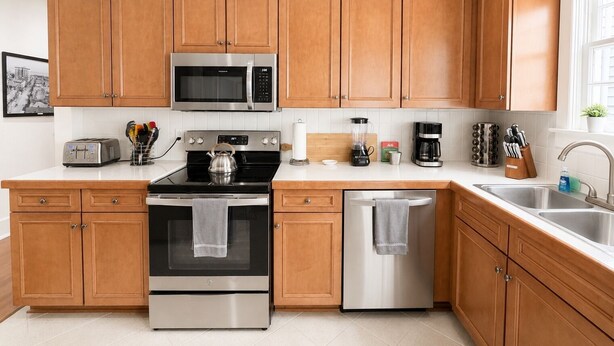 Una cucina moderna con mobili in legno, elettrodomestici in acciaio inossidabile, un tostapane e una macchina per il caffè.