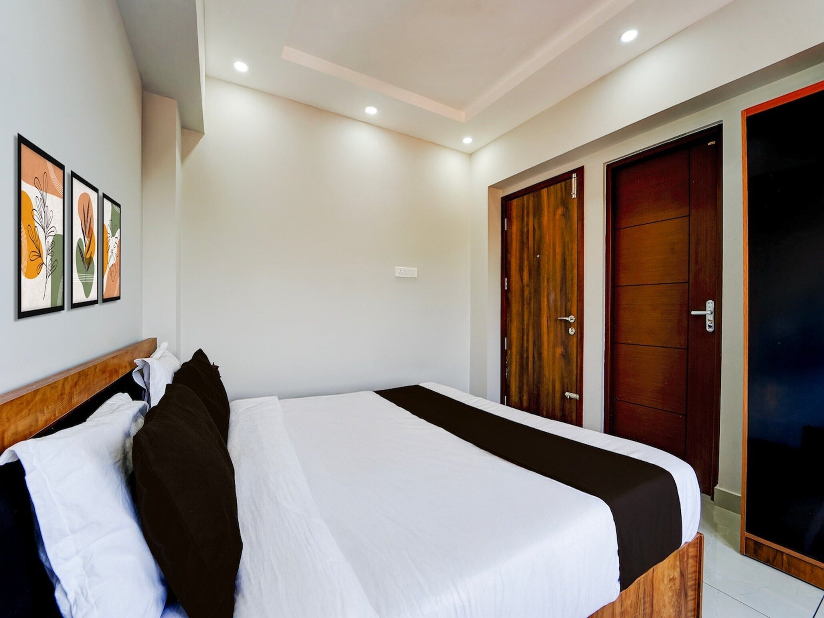 Una camera d'albergo con un letto, una testiera in legno, un armadio e una porta.