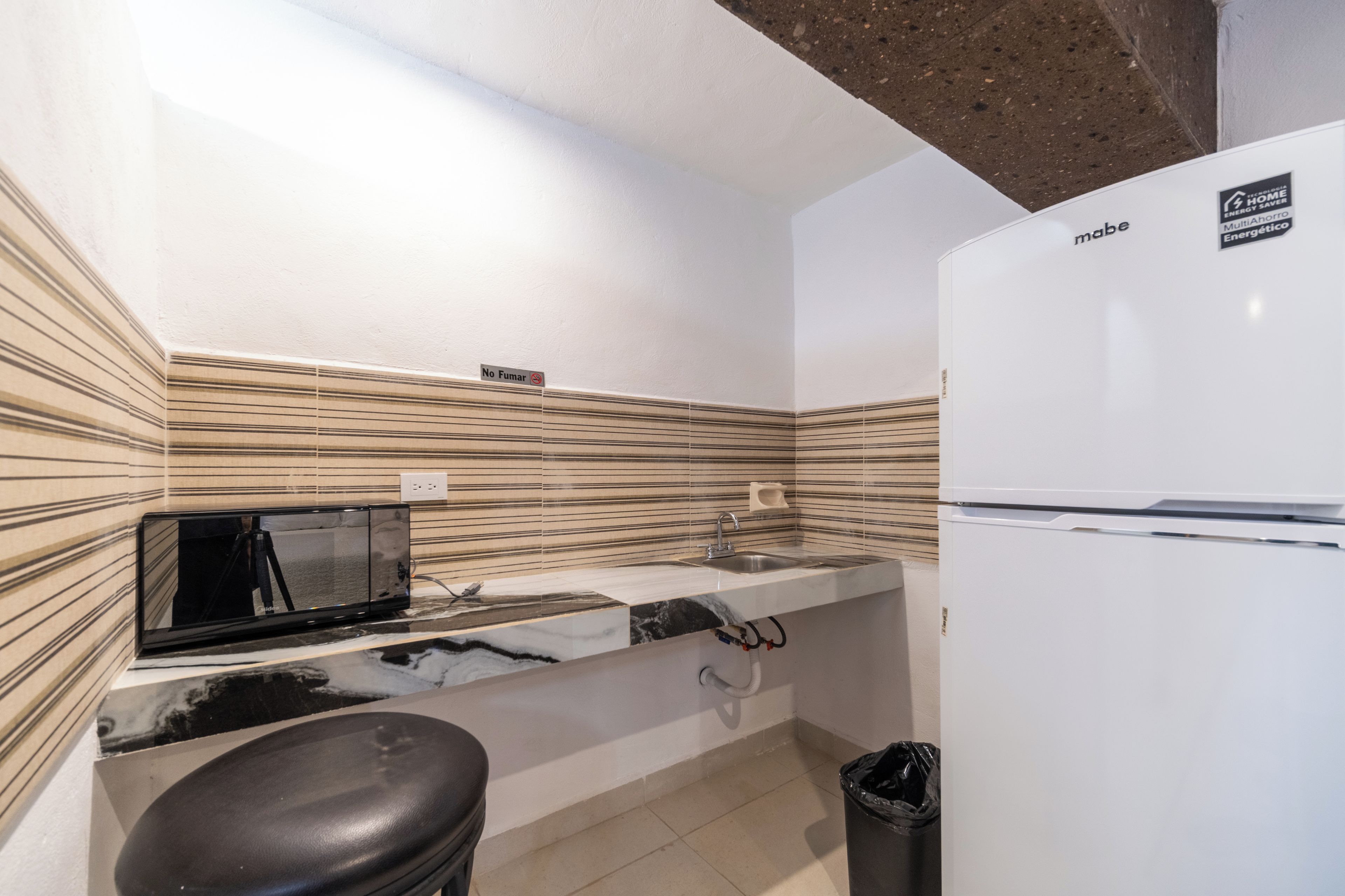 A compact kitchen with a microwave, sink, and refrigerator.