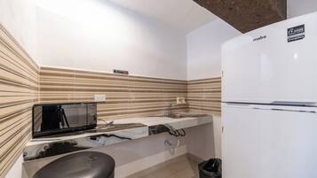 A compact kitchen with a microwave, sink, and refrigerator.