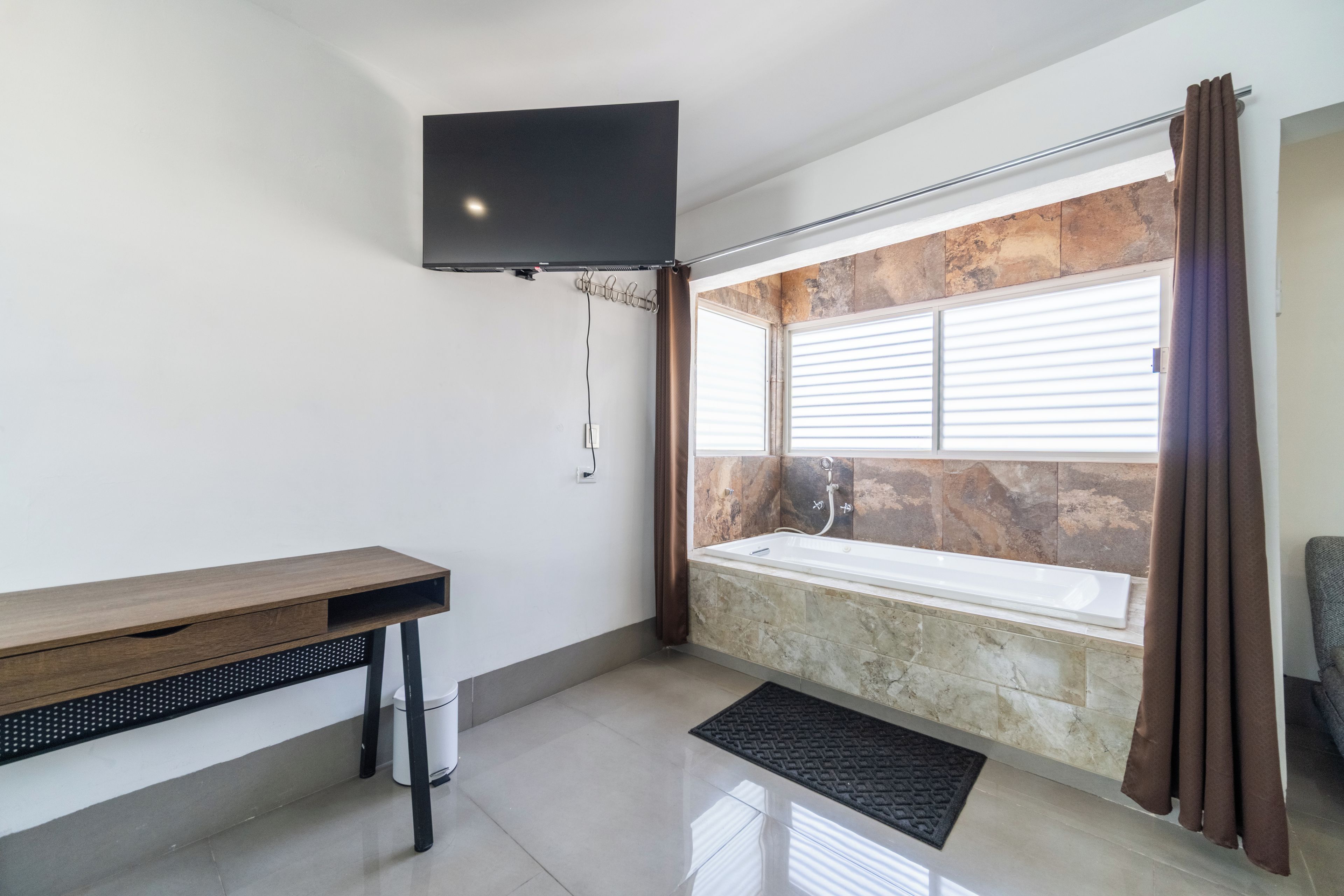 A modern bathroom with a wooden vanity, a bathtub, and a shower.