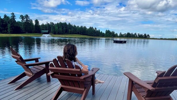 A wooden deck with Adirondack chairs overlooking a calm lake, surrounded by trees. - Serenity Retreat - Mountain Escape- Grandview Peaks (Nebo)