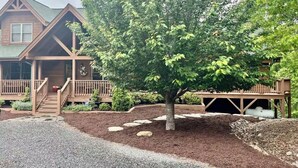 A two-story wooden house with a porch, a tree in the front yard, and a gravel driveway. - Serenity Retreat - Mountain Escape- Grandview Peaks (Nebo)