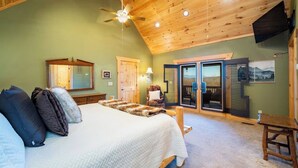 A bedroom with a bed, pillows, a wooden ceiling, a ceiling fan, a chair, a bench, a door, and a window. - Serenity Retreat - Mountain Escape- Grandview Peaks (Nebo)