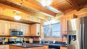 A kitchen with wooden cabinets, stainless steel appliances, and a central island. - Serenity Retreat - Mountain Escape- Grandview Peaks (Nebo)