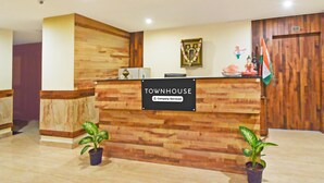 A reception desk with a sign reading 'Townhouse Company-Serviced.' - Deluxegrace Complex (Hyderabad)