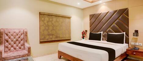 A bedroom with a bed, a chair, a nightstand, and a wall with a geometric pattern.