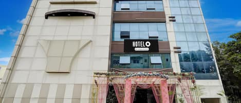 A modern hotel building with a sign reading 'HOTEL O & Company-Serviced.'