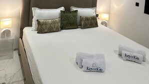 A modern hotel room with a large bed, three abstract paintings, and two KeyndGo towels. - Absolute Comfort in a Luxury Residence, Soukra (Tunis)