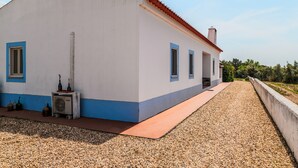 A building with a white facade, blue trim, and a red-tiled roof.