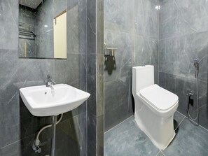 Un baño con lavamanos, inodoro y ducha blancos.