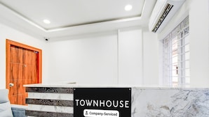 A reception area with a sign reading 'TOWNHOUSE & Company-Serviced.' - Super Townhouse JP Nagar Miyapur (Hyderabad)