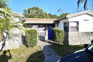 A residential house with a blue door, a garage, and a stone wall. - Hollywood 3801 (Hollywood)