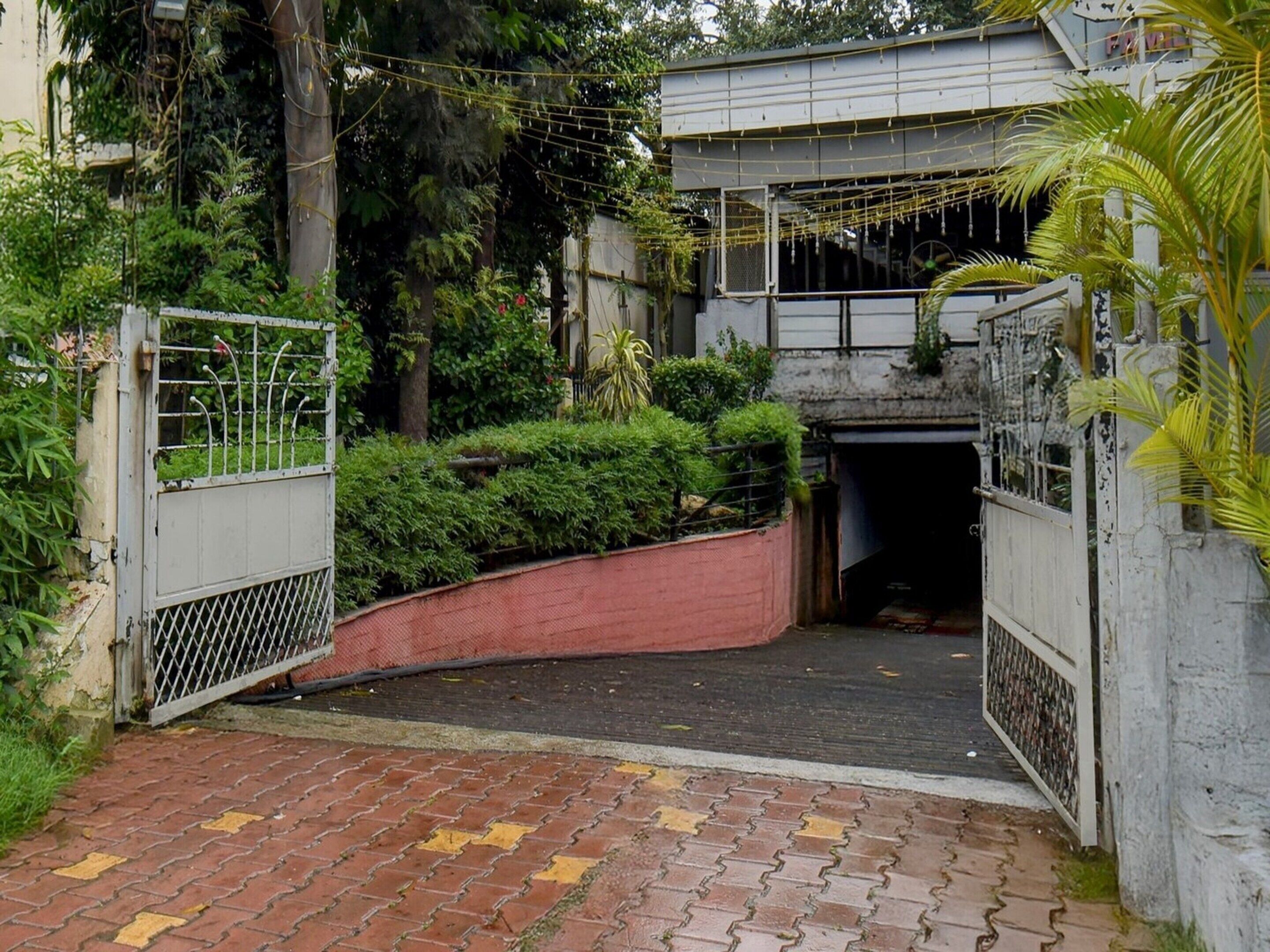 A gated entrance with a brick pathway leading to a building.