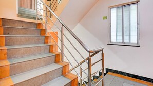 Eine Treppe mit Metallgeländern, einem Brandschutzschild und einem Fenster mit Jalousien.