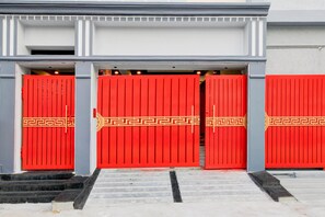 A building entrance with three red doors, each with a decorative pattern. - Deluxekhajaguda Premium Suites (Hyderabad)