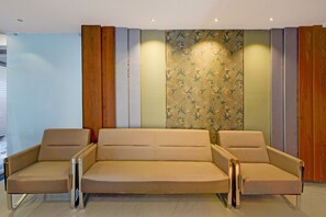 A modern living room with a sofa set, wooden paneling, and patterned wallpaper. - Deluxekhajaguda Premium Suites (Hyderabad)