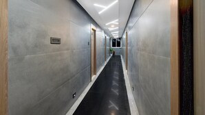 A modern hallway with a black floor, grey walls, and recessed lighting. - Deluxekhajaguda Premium Suites (Hyderabad)