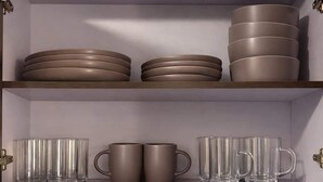 A cabinet with shelves containing plates and mugs. - Milan Providencia Studio (Guadalajara)