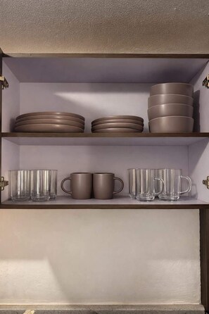 Ein Schrank mit Regalen, gefüllt mit Tellern und Tassen.