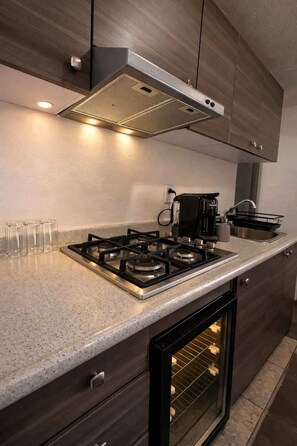 Eine moderne Küche mit Gasherd, Kaffeemaschine und Backofen.
