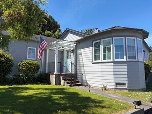 Ein Haus mit einer Veranda, einer Flagge und der Hausnummer 485 an der Tür.