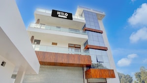 A multi-story hotel with a sign reading 'HOTELO & Company Services.' - Deluxebellandur Near Embassy Tech Village (Bakshi Ka Talab)