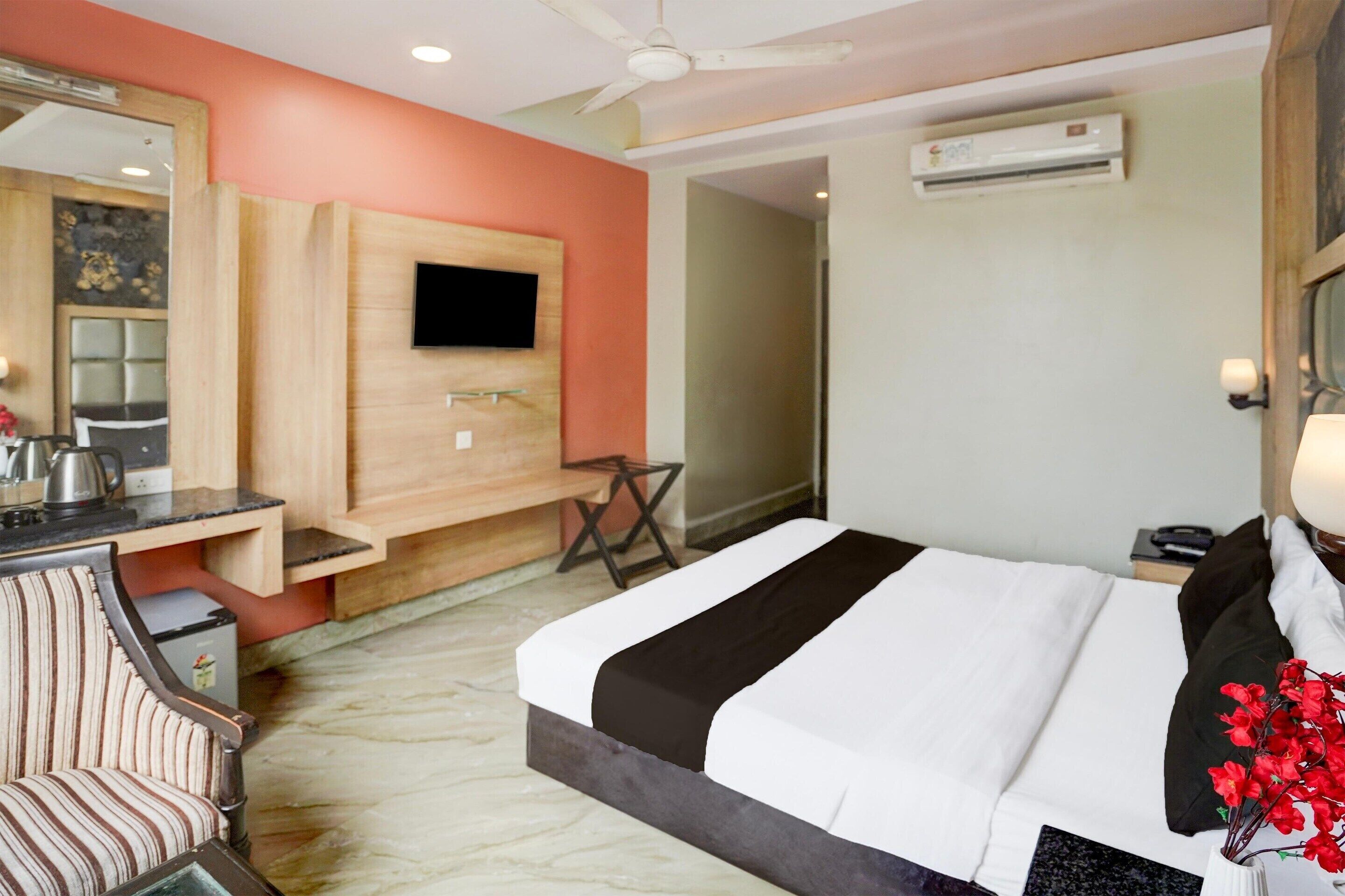 Une chambre d’hôtel équipée d’un lit, d’un bureau, d’une chaise, d’une télévision et d’un appareil de climatisation.