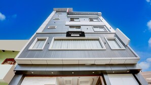 En modern byggnad med en skylt som visar texten ”TOWNHOUSE” och en logotyp för ett företag som erbjuder service.