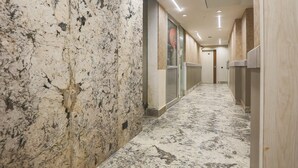 A marble-floored hallway with glass doors and wooden paneling. - Deluxe Hotel Heritage Plaza (Hisar)