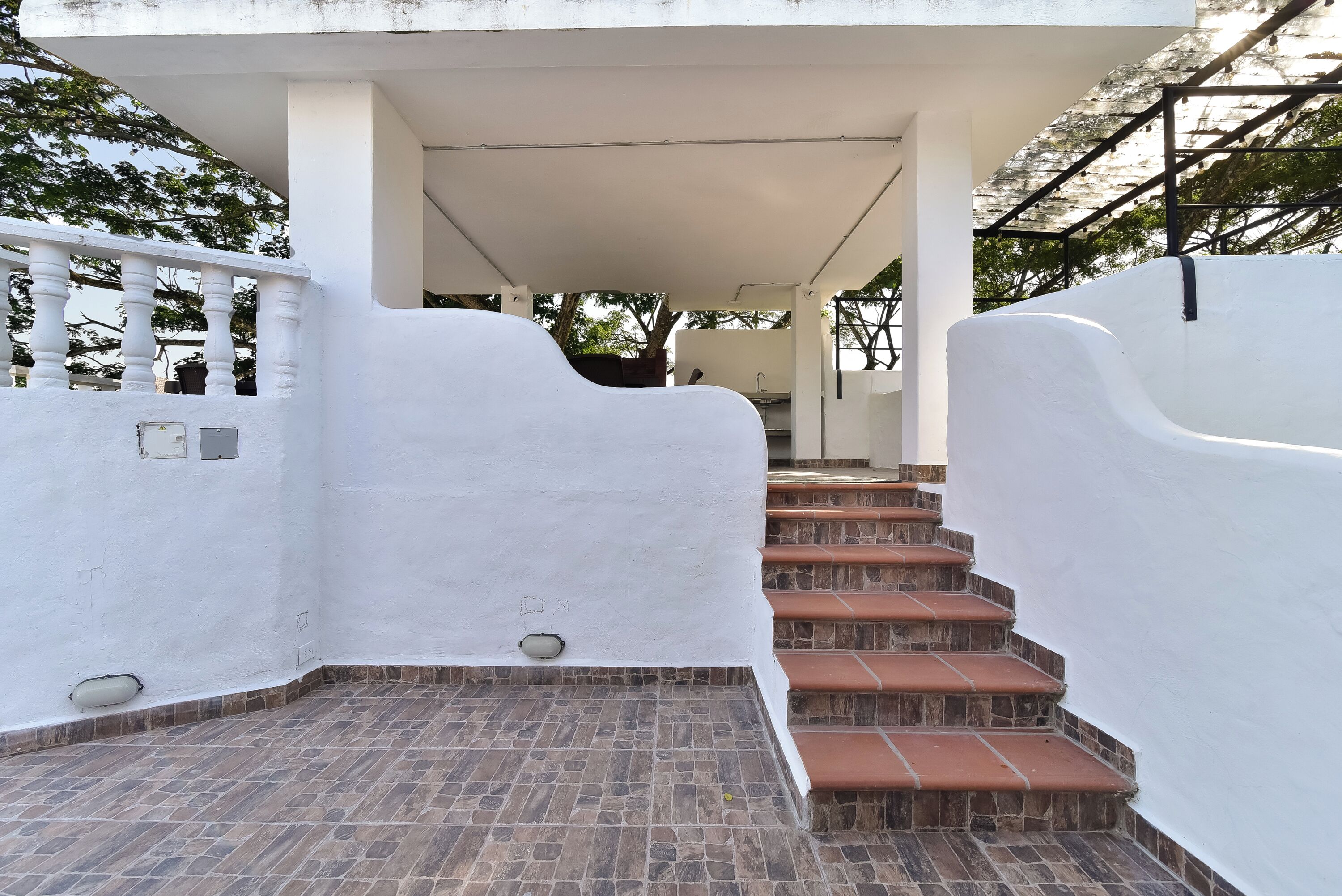 Un edificio blanco con una escalera cubierta que lleva a un nivel superior.