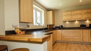 Una cocina moderna con armarios de madera, una isla integrada, un fregadero y un ventanal.