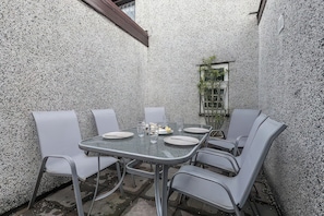 Ein Essbereich mit einem für sechs Personen gedeckten Tisch, umgeben von sechs Stühlen, an einer strukturierten Wand.