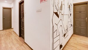 A hallway with wooden flooring, a wall-mounted sign indicating rooms 205-208, and a door with the number 204. - Deluxehotel Woodland (Nagpur)