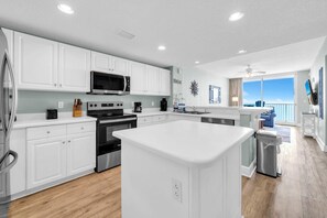 A modern kitchen with white cabinetry, stainless steel appliances, and a large island. - Majestic Beach Towers 2-1704 (Panama City Beach)
