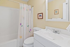 A bathroom with a shower curtain, toilet, sink, and mirror. - Summerhouse Townhomes #2- Changes in Attitude (Miramar Beach)