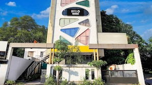 Een modern hotel met een unieke geometrische gevel, een zichtbare trap en een heldere lucht.