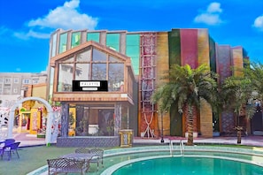 A hotel with a pool, outdoor seating, and a sign reading 'PALETTE.'
