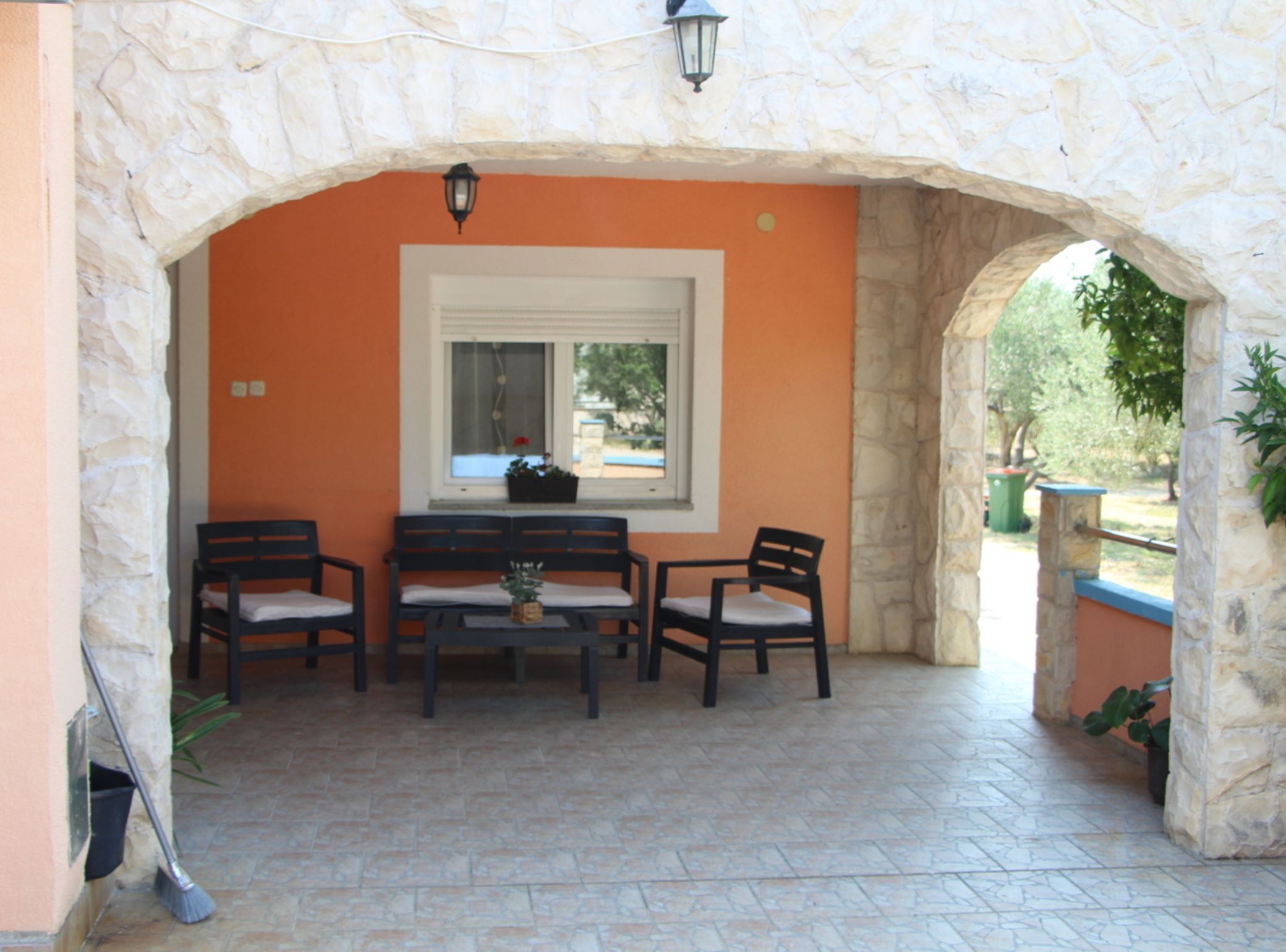 A patio with stone walls, a table, and four chairs.