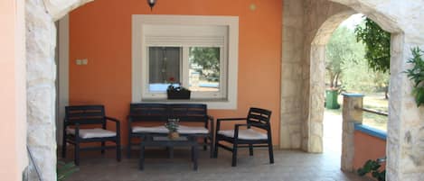 A patio with stone walls, a table, and four chairs.