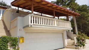 A two-story building with a covered balcony, a garage, and a staircase. - Villa Azure Saplunara (Mljet)