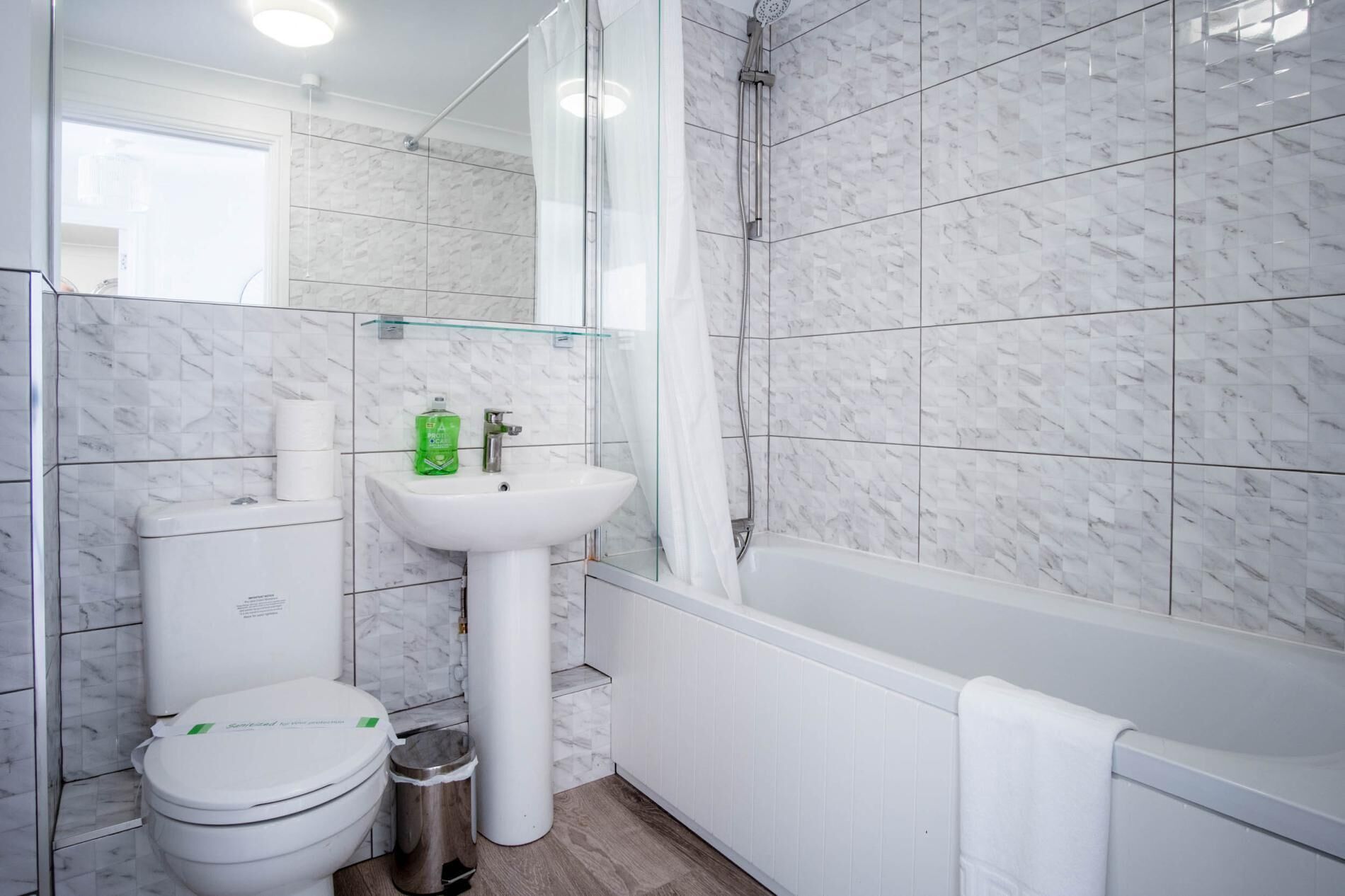 Un baño con inodoro, lavamanos, ducha y bañera.