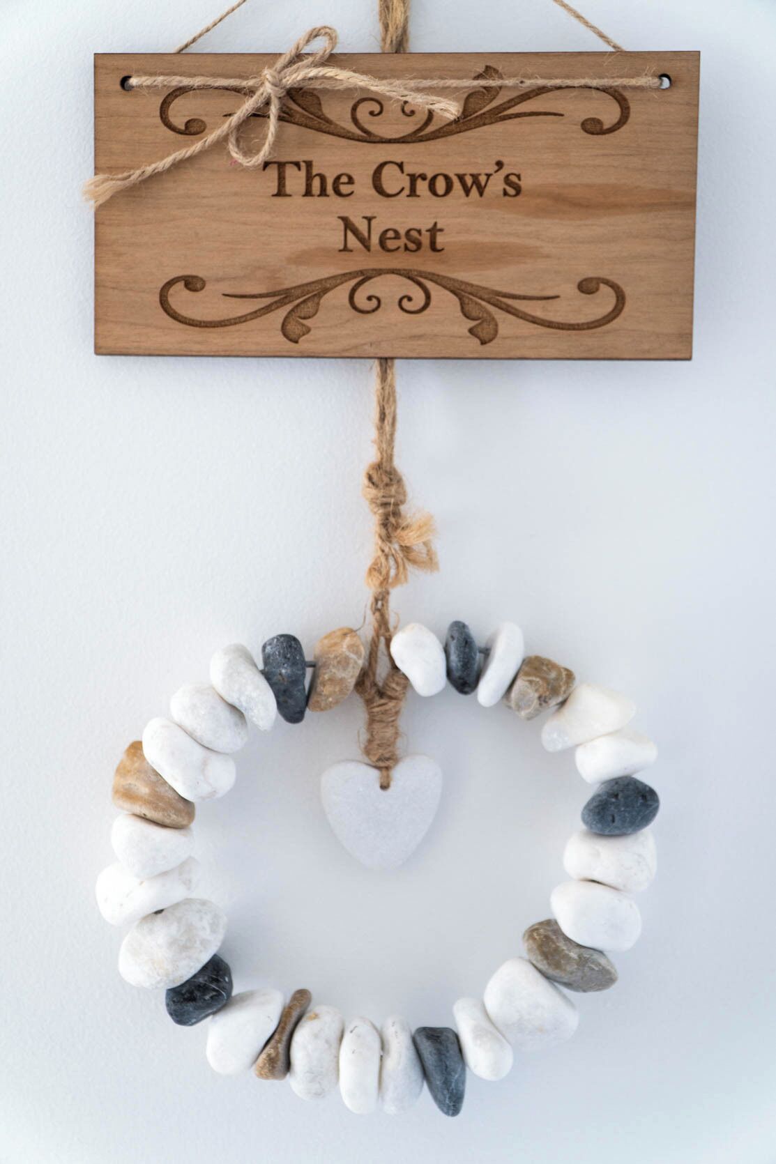 A wooden sign with the text 'The Crow's Nest' and a stone wall below it.