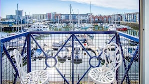 A balcony with a view of a marina, boats, and buildings in the background. - The Crows Nest - 1 Bed Apartment - Swansea Marina (Swansea)