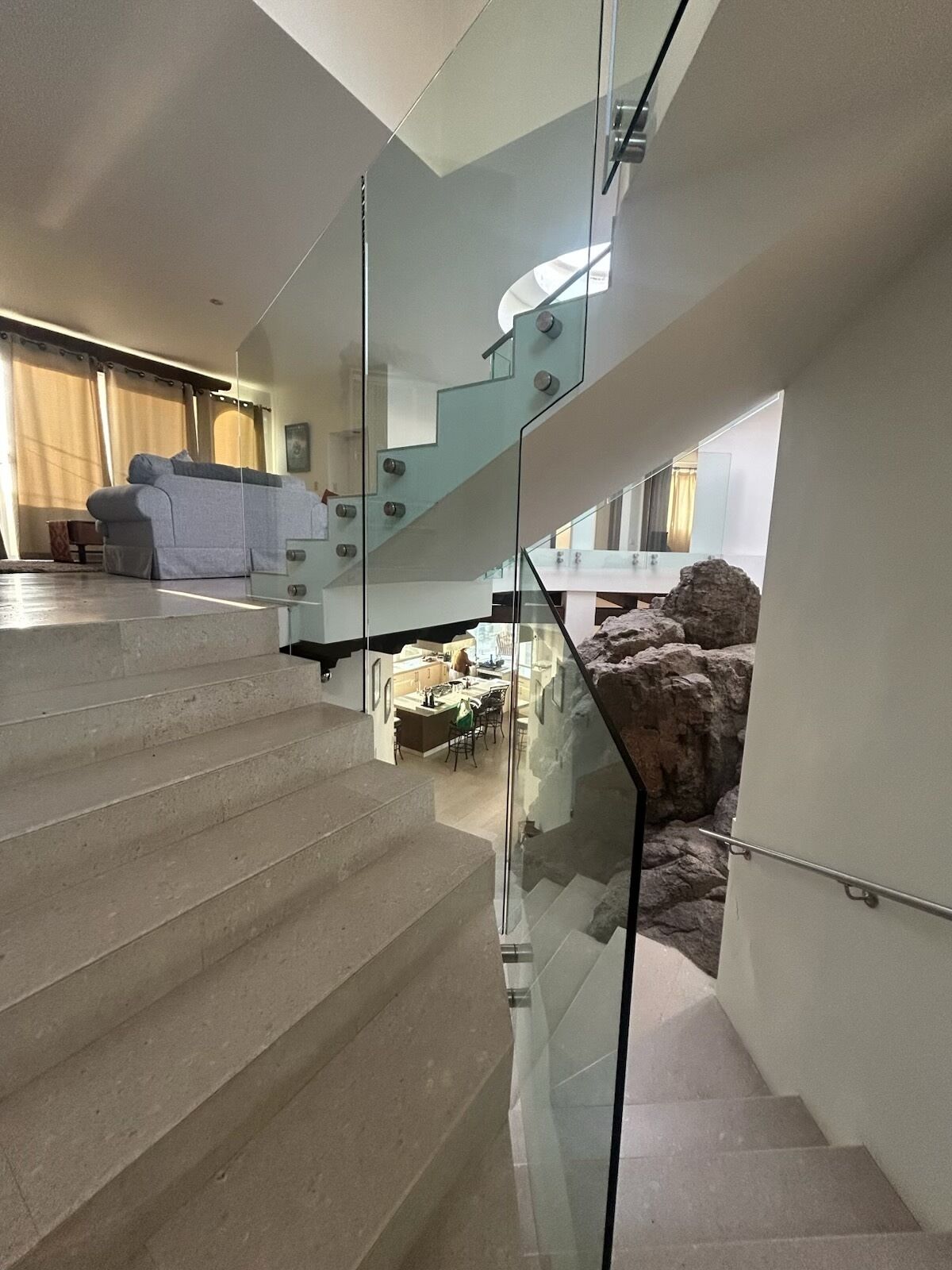 Un intérieur moderne comprenant un escalier, un espace de vie avec un canapé et un coin cuisine.